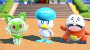 The three Pokémon Sprigatito, Quaxly, and Fuecoco. Sprigatito is a green cat, Quaxly is a blue and white duck, and Fuecoco is a red and yellow crocodile.