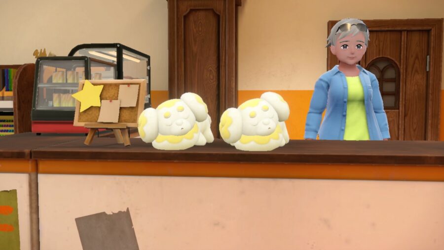 Two of the Pokémon Fidough sleeping on a counter. They have soft yellow bodies and ears like donuts.