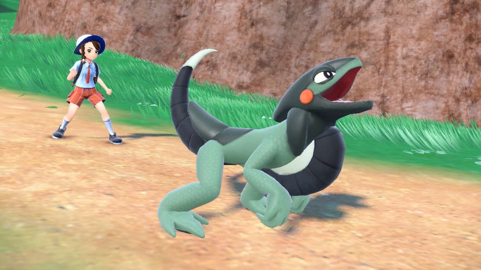 The Pokémon Cyclizar. It has four green legs, a black tail, a lizard-like face, and a large wheel-like structure protruding from its neck.