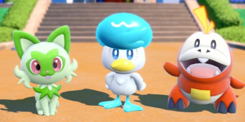 The three Pokémon Sprigatito, Quaxly, and Fuecoco. Sprigatito is a green cat, Quaxly is a blue and white duck, and Fuecoco is a red and yellow crocodile.