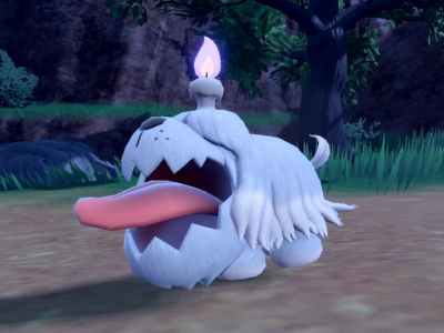 The Pokémon Greavard. It is a white, dog-like Pokémon with a large tongue, with a purple candle on top of its head.